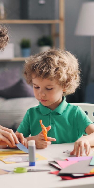 Mother and young child crafting together indoors, fostering creativity and bonding.