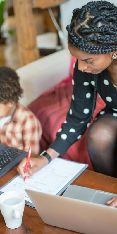 Mother multitasking with work and child at home, showcasing modern parenting.